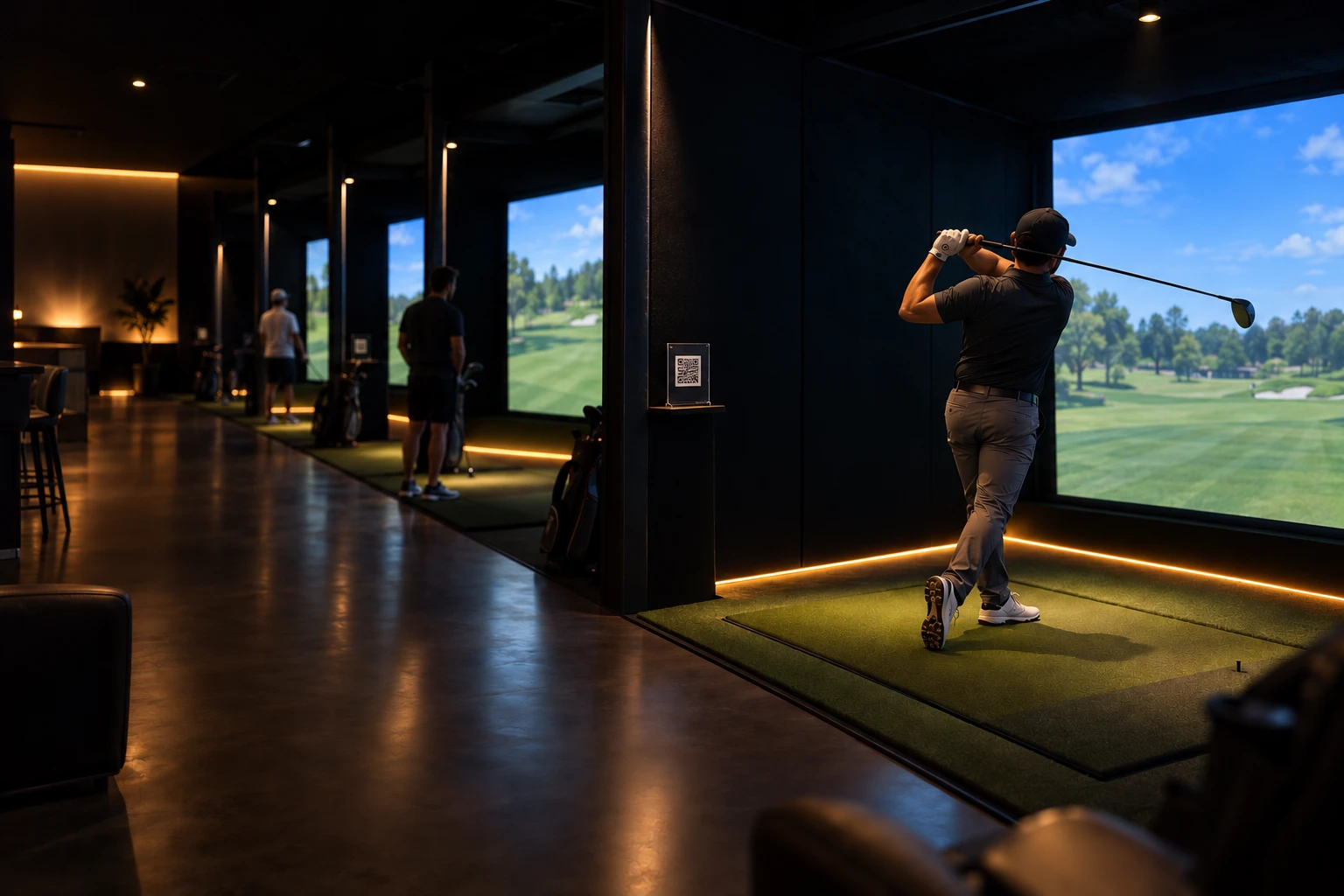 A golfer finishing a swing on a simulator bay